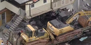 Carreta que levava tratores perde freio, bate e destrói muro de casa e deixa dois feridos em Caieiras